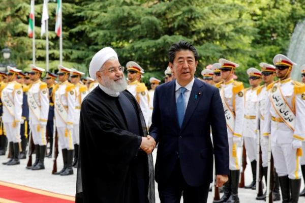 الرئيس الايراني حسن روحاني (يسار) مستقبلا رئيس الوزراء الياباني شينزو آبي في القصر الرئاسي في طهران
