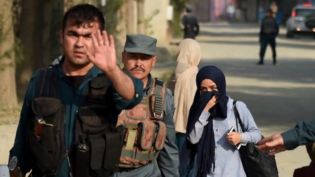 الشرطة الافغانية تواكب طالبة كانت عالقة داخل حرم الجامعة الامريكية في كابول بعد هجوم استمر 10 ساعات، 24 اغسطس 2016 