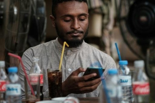 الشاب السوداني محمد عمر يتصل بالإنترنت على هاتفه النقال في أحد مقاهي الخرطوم