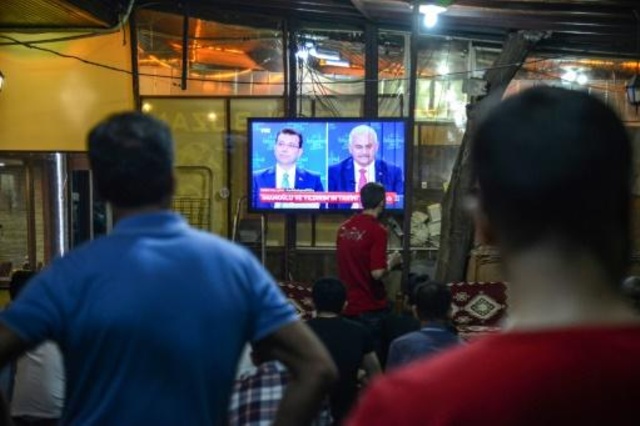 مواطنون أتراك يتابعون مناظرة تلفزيونية بين المرشحين لرئاسة بلدية اسطنبول يلديريم وإمام أوغلو