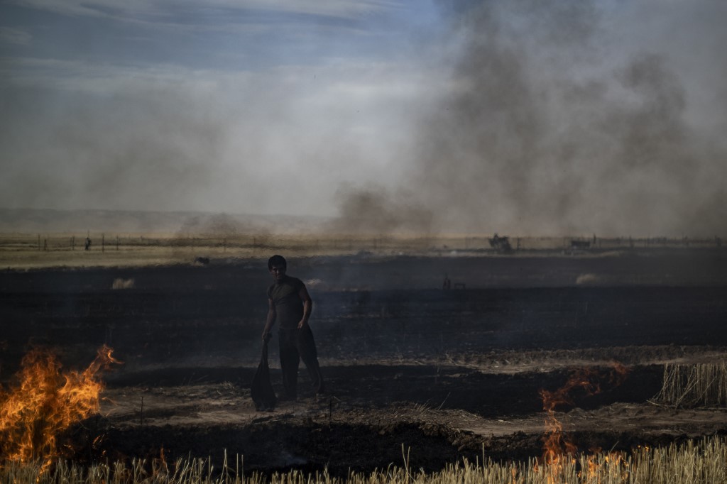 مزارع في شمال سوريا يحاول اطفاء نيران تلتهم حقلا للقمح