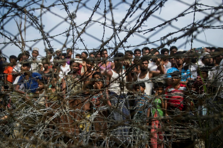 صورة التقطت من منطقة ماونغداو في ولاية راخين بتاريخ 25 نيسان/ابريل 2018 تظهر اللاجئين الروهينغا يتجمعون خلف سياج عند الحدود بين بورما وبنغلادش