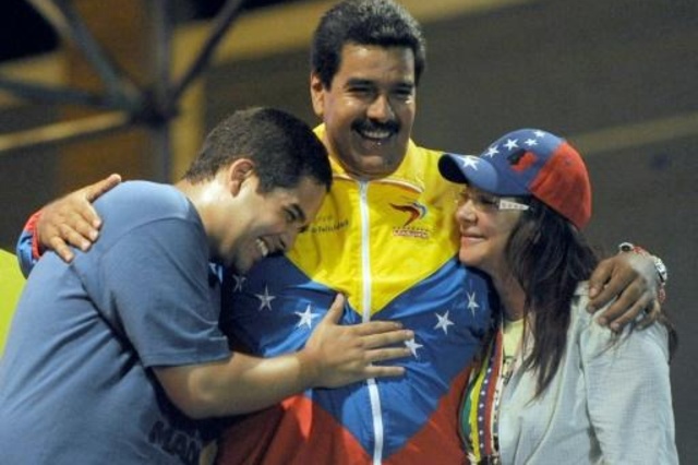 الرئيس الفنزويلي نيكولاس مادورو معانقا زوجته ونجله خلال تجمع انتخابي في 2013