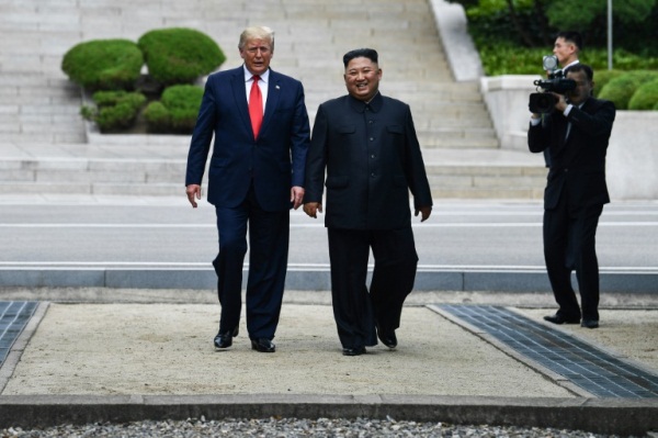 الزعيم الكوري الشمالي كيم جونغ أون يسير برفقة الرئيس الأميركي دونالد ترمب في الجهة الشمالية من الحدود بين الكوريتين في المنطقة المنزوعة السلاح في قرية بانمونجوم