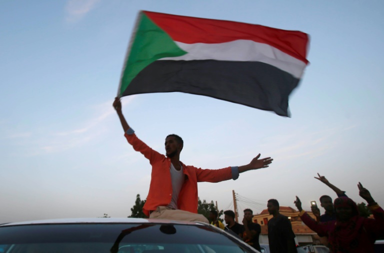 سودانيون بحتفلون في شوارع الخرطوم بعد إعلان المجلس العسكري وقادة الاحتجاجات التوصل إلى اتفاق في 5 تموز/يوليو 2019