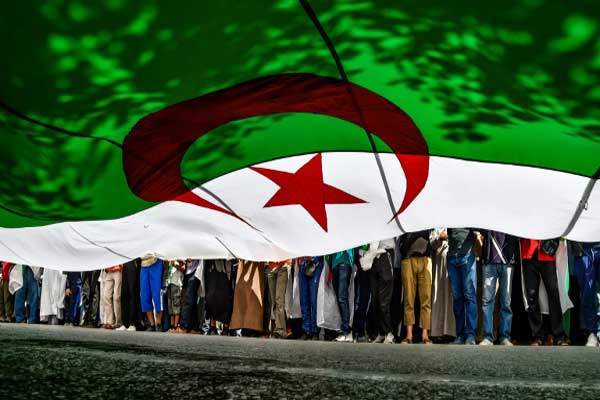 متظاهرون جزائريون يرفعون علمًا عملاقًا لبلدهم في العاصمة في 31 مايو 2019