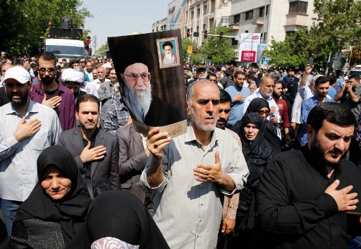 ايرانيون يرفعون صورة خامنئي خلال مسيرة احتجاجية