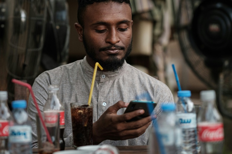 الشاب السوداني محمد عمر يتصل بالإنترنت على هاتفه النقال في أحد مقاهي الخرطوم في 17 يونيو 2019