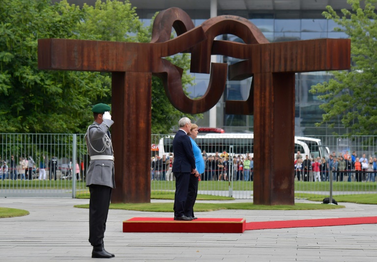 المستشارة الألمانية أنغيلا ميركل ورئيس الوزراء الفنلندي انتي ريني يستمعان إلى نشيدي بلديهما في المستشارية في برلين في 10 يوليو 2019