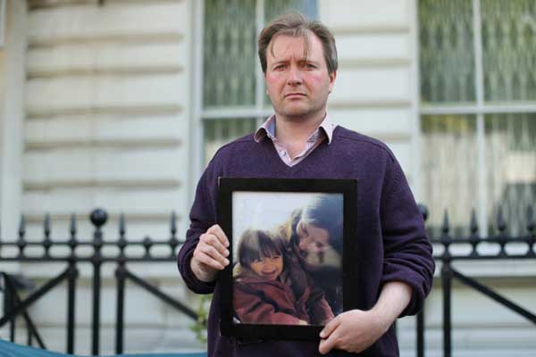 ريتشارد راتكليف يحمل صورة زوجته نازانين المسجونة في إيران وطفلته خلال اعتصام أمام السفارة الإيرانية في لندن بتاريخ 17 يونيو 2019