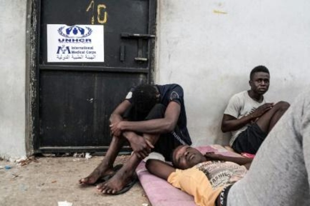مهاجرون غير شرعيين يجلسون في مركز احتجاز في الزاوية على بعد 45 كلم غرب العاصمة طرابلس