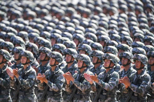 جنود صينيون يصفقون خلال عرض عسكري في ذكرى تأسيس الجيش الأشتراكي الصيني في 1927، والذي بات اليوم جيش التحرير الشعبي في قاعدة زهوريه في مونغوليا الداحلية في 2017