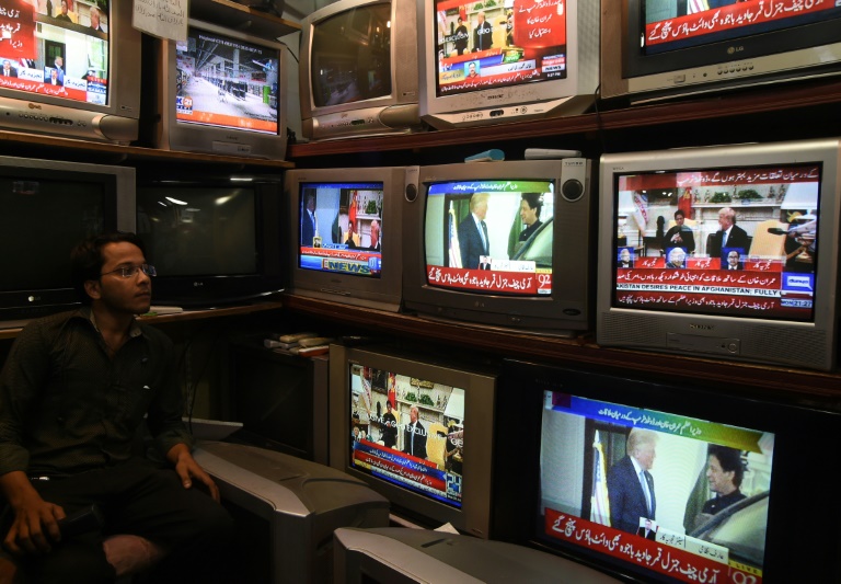 تاجر باكستاني يتابع اجتماع الرئيس الأميركي دونالد ترمب ورئيس وزراء باكستان عمران خان، في محله في كراتشي الأحد 22 تموز/يوليو 2019