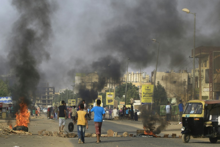 متظاهرون يحرقون إطارات السيارات في وسط شارع رئيسي في الخرطوم في 27 تموز/يوليو 2019 احتجاجا على نتائج التحقيق في فض اعتصام الخرطوم في حزيران/يونيو