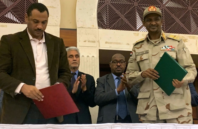 نائب رئيس المجلس العسكري الحاكم محمد حمدان دقلو (يمين) وممثل قوى الحرية والتغيير أحمد الربيع (يسار) بعد التوقيع الأحرف الأولى على وثيقة الاتفاق السياسي في السودان، في الخرطوم في 17 تموز/يوليو 2019. 