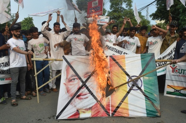 ناشطون باكستانيون يحرقون علما هنديا وصورة لرئيس الوزراء الهندي ناريندرا مودي خلال تظاهرة في لاهور في 5 أغسطس 2019