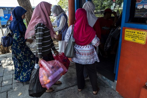 مواطنة أندونيسية تحمل عبوات بلاستيكية لاستبدالها بتذكرة سفر بالحافلة