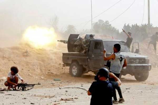 مقاتلون من القوات الموالية لحكومة الوفاق الوطني الليبية المعترف بها دوليًا يطلقون النار في الخامس والعشرين من مايو 2019 على مقاتلين موالين للمشير خليفة حفتر على طريق المطار في جنوب العاصمة طرابلس