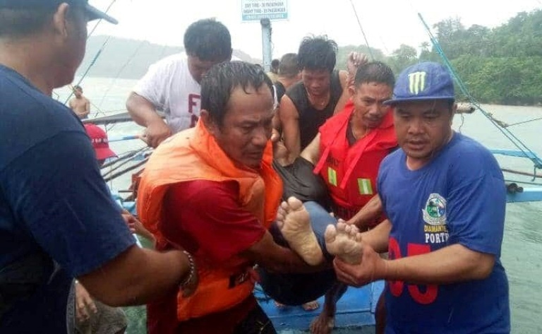 صورة وزعها خفر السواحل الفيليبيني السبت 3 أغسطس 2019 تظهر صيادين يحملون جثة أحد الضحايا بعد غرق مراكب في مضييق إيلويلو-غيماراس