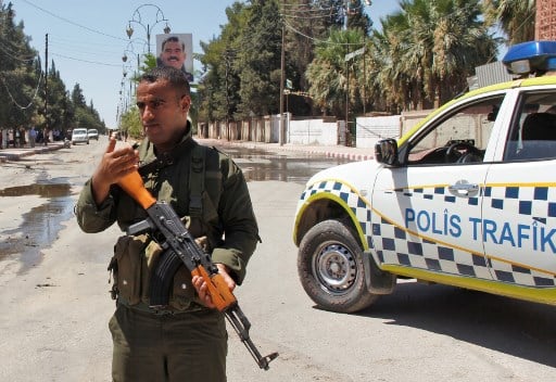 عنصر من الشرطة الكردية بُعيد تفجير سيارة مفخخة في القحطانية بمحافظة الحسكة السورية 