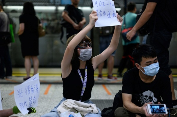 متظاهرون يحملون شعارات في محطة كولون تونغ في هونغ كونغ في 21 أغسطس 2019