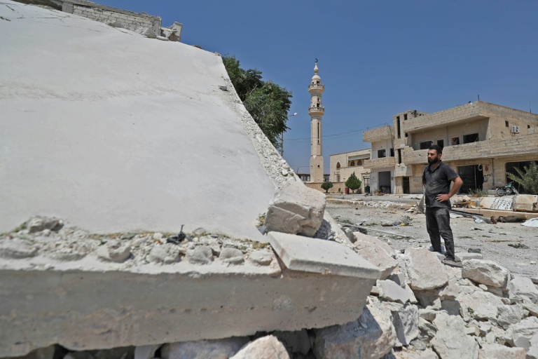 نازح سوري من خان شيخون كبرى بلدات ريف ادلب الجنوبي يقف أمام منزله المدمر في البلدة في 3 اغسطس 2019