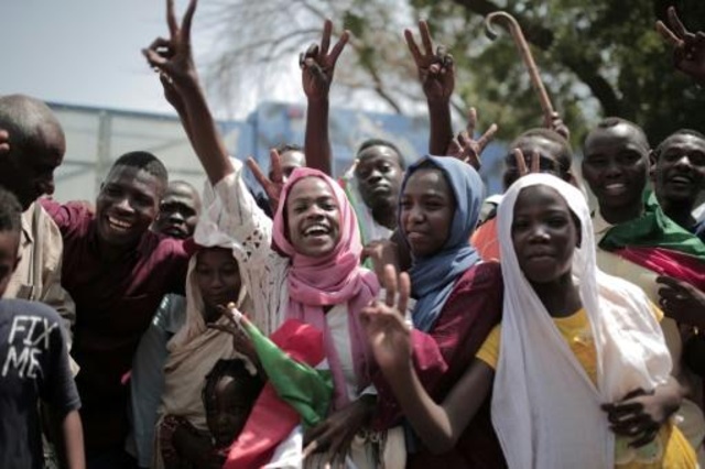 سودانيات يحتفلن أمام قاعة الصداقة حيث كان يجري تشكيل مجلس حاكم جديد غالبيته من المدنيين وسط الخرطوم