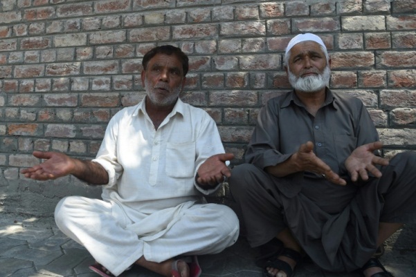 رجلان كشميريان ينتظران أمام مركز للشرطة في سريناغار لمعرفة اخبار عن اقاربهم الذين يقولون ان السلطات تحتجزهم