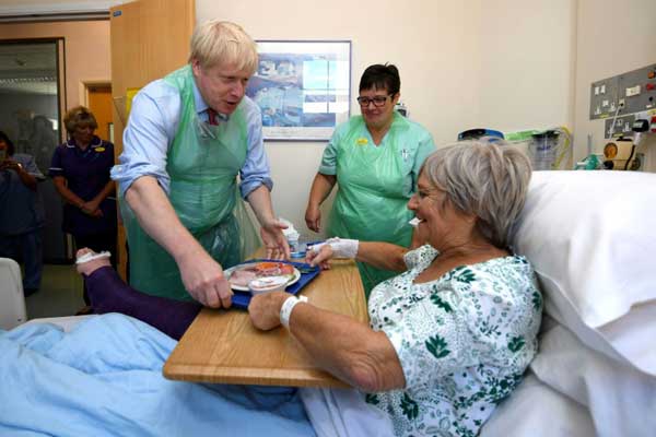 جونسون يقدم الطعام إلى مريضة خلال زيارته مستشفى في توركواي في جنوب غرب بريطانيا بتاريخ 23 أغسطس 2019