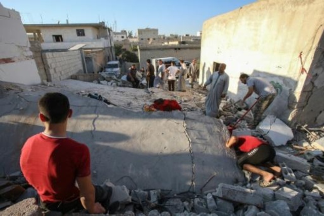 مدنيون سوريون يبحثون عن ناجين بين أنقاض مبنى مدمر نتيجة غارة سورية قرب معرة النعمان في شمال غرب سوريا في 27 أغسطس 2019