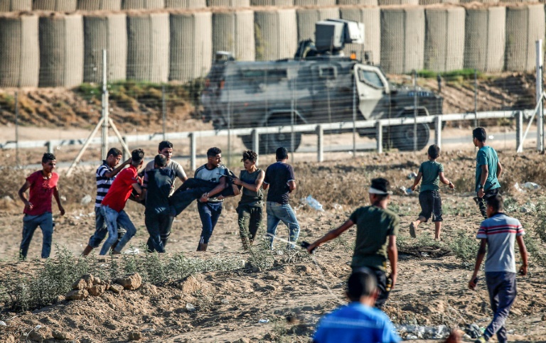 محتجون فلسطينيون ينقلون جريحا خلال مواجهات مع الجنود الاسرائيليين على حدود غزة في السادس من ايلول/سبتمبر 2019