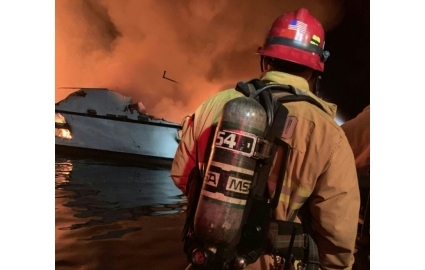 صورة وزعتها مقاطعة فينتورا يظهر فيها رجل إطفاء يحاول إخماد حريق على متن سفينة قبالة كاليفورنيا