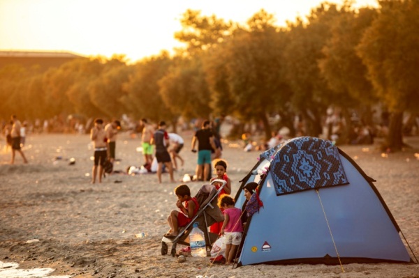 عائلة سورية تجلس في خيمة على شاطئ مينكشه باسطنبول، في 28 يوليو 2019