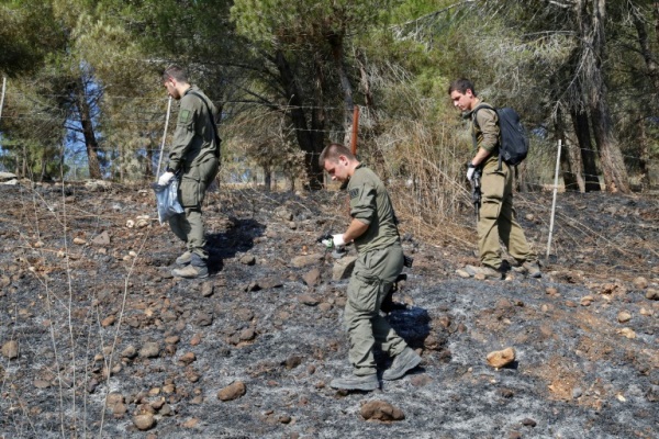 جنود إسرائيليون يفحصون شظايا المقذوفات التي أطلقها حزب الله