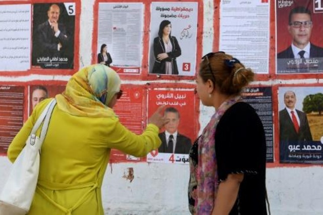 تونسيتان تنظران الى لافتات انتخابية في الثاني من سبتمبر 2019