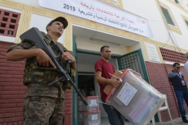 عناصر من الهيئة العليا المستقلة للانتخابات في تونس أثناء توزيع صناديق الاقتراع