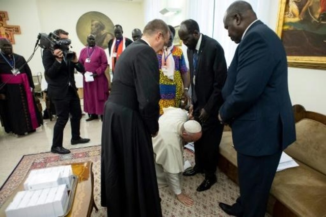 البابا فرنسيس يركع ليقبل قدمي كل من زعيمي الطرفين المتحاربين في جنوب السودان، في الفاتيكان في 11 نيسان/ابريل 2019