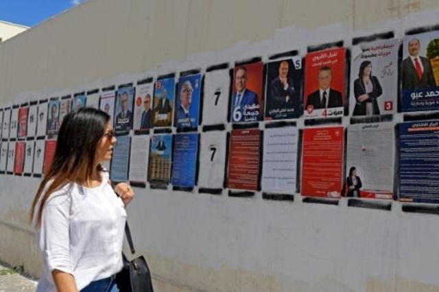 تونسية تمر قرب لافتات انتخابية في العاصمة