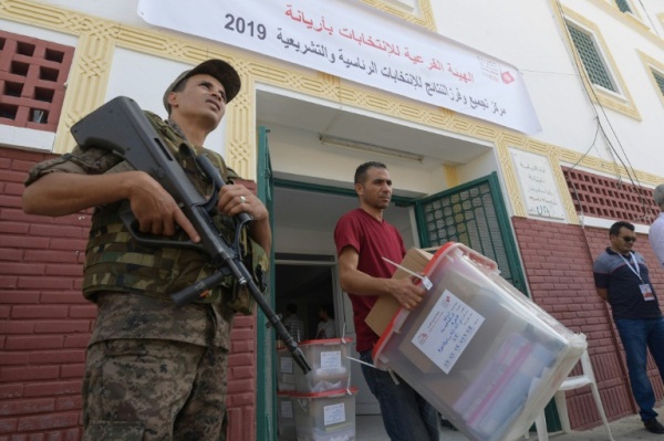 عناصر من الهيئة العليا المستقلة للانتخابات في تونس أثناء توزيع صناديق الاقتراع عشية الاقتراع الرئاسي