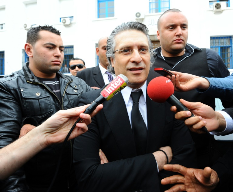 نبيل القروي (وسط)، مؤسس قناة نسمة التلفزيونية، أثناء خروجه من محكمة في تونس العاصمة، 19 نيسان/ابريل 2012