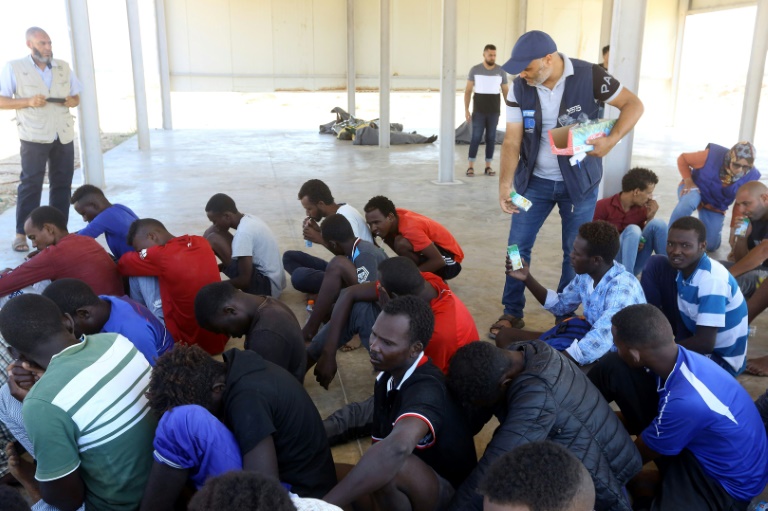 مهاجرون تم إنقاذهم يتلقون مساعدات غذائية في منطقة الخمس قرب العاصمة الليبية طرابلس في 27 آب/أغسطس 2019