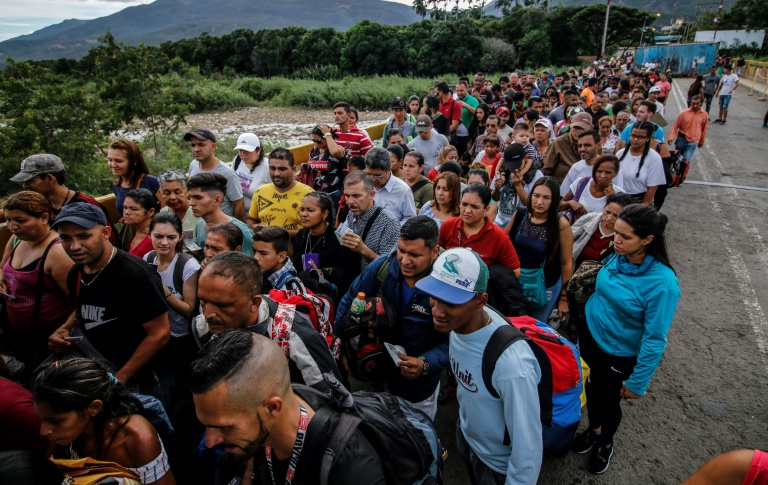 فنزويليون يقفون في طاوبير عند الجسر الذي يصل سان انطونيو دل تاتشيرا في فنزويلا بمدينة كوكوتا في كولومبيا في التاسع من حزيران/يونيو 2019