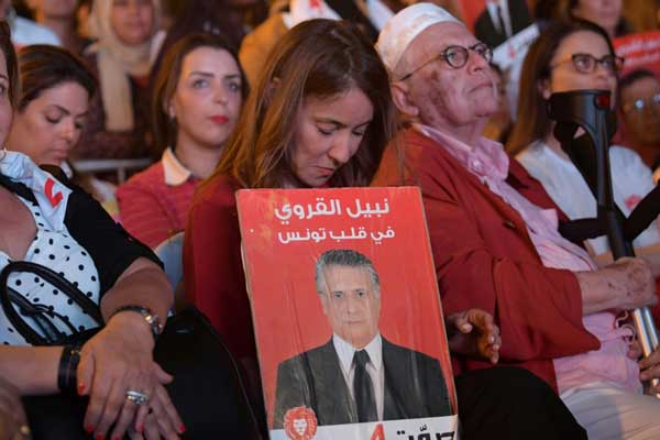 سلوى سماوي زوجة المرشح للانتخابات الرئاسية التونسية الموقوف بشبهة فساد نبيل القروي، تحمل صورة زوجها أثناء تجمع انتخابي في 13 سبتمبر 2019 في العاصمة التونسية