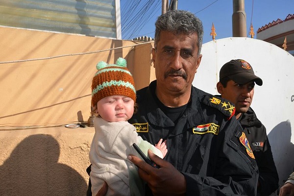 الفريق الركن عبد الوهاب الساعدي يحمل طفلا في جولة لاحياء محررة بالموصل