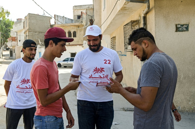 رجل يوزع منشورات انتخابية في العاصمة تونس في 2 اكتوبر 2019
