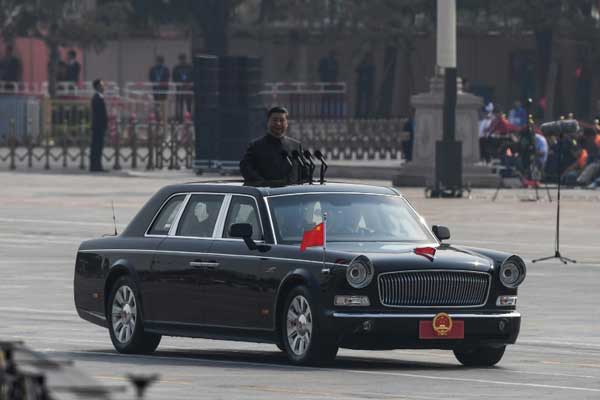 الرئيس الصيني شي جينبينغ مستعرضًا من على متن سيارة الوحدات المشاركة في العرض العسكري في ساحة تيان إنمين في بكين في مستهل الاحتفالات بالذكرى السبعين لتأسيس جمهورية الصين الشعبية في 1 أكتوبر 2019