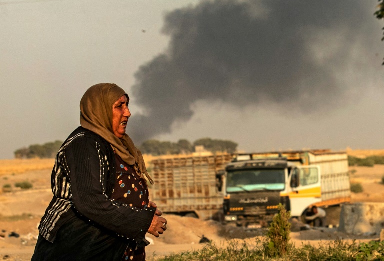 سيدة تفر من القصف التركي على بلدة رأس العين في محافظة الحسكة في شمال شرق سوريا في 9 أكتوبر 2019 