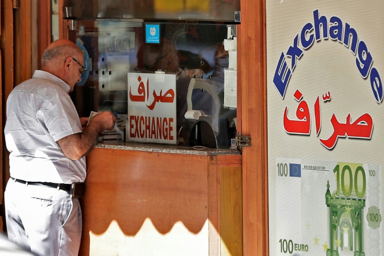 رجل يحصي مبلغاً من المال أمام مكتب صيرفة في بيروت مطلع أكتوبر 2019
