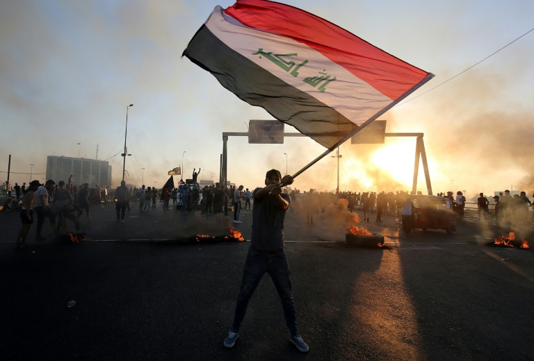 متظاهر عراقي يلوح بعلم بلده في وسط العاصمة بغداد في 5 أكتوبر 2019