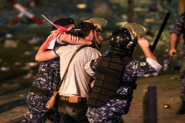 قوات أمنية تعتقل أحد المتظاهرين في ساحة رياض الصلح في وسط بيروت في 18 أكتوبر بعد أعمال شغب أعقبت تظاهرات حاشدة ليلًا